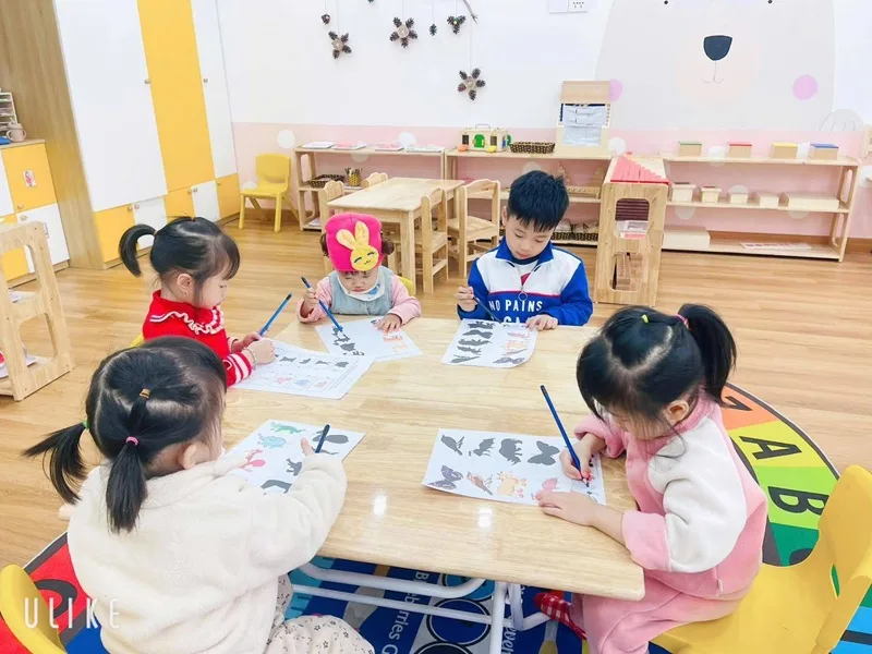 Không gian lớp học mở với các kệ giáo cụ bằng gỗ vừa vặn với tầm vóc của trẻ.
